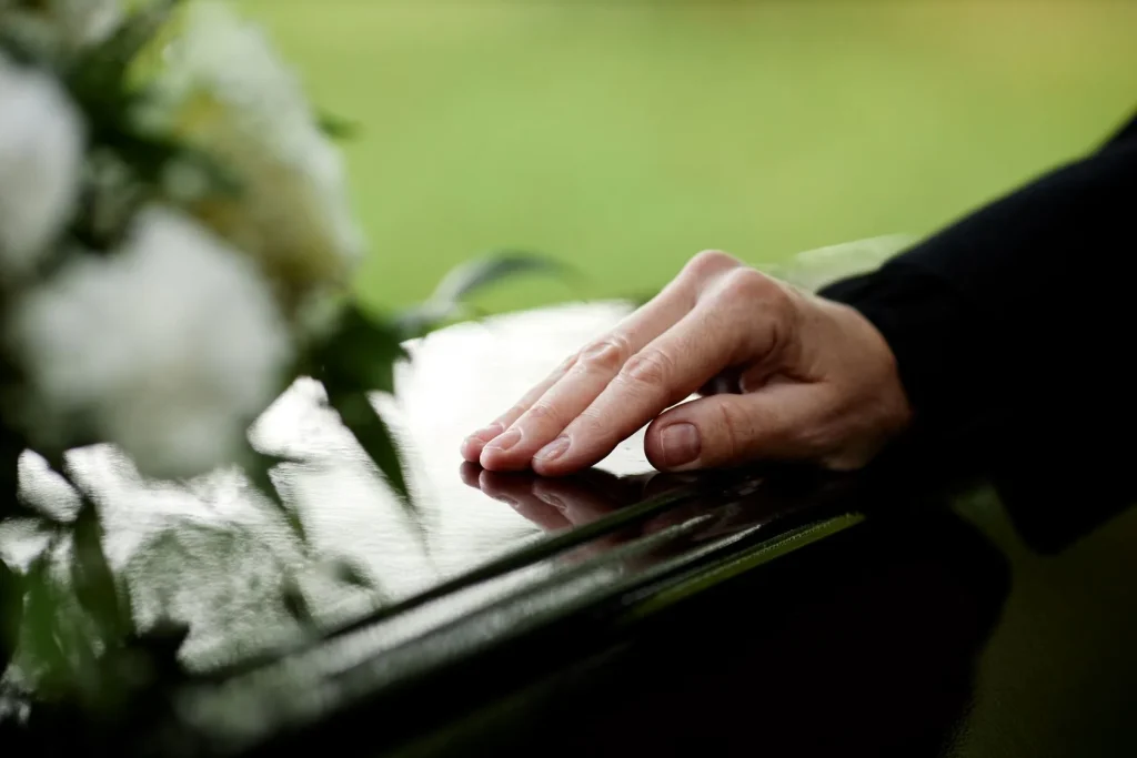 A hand on a coffin.
